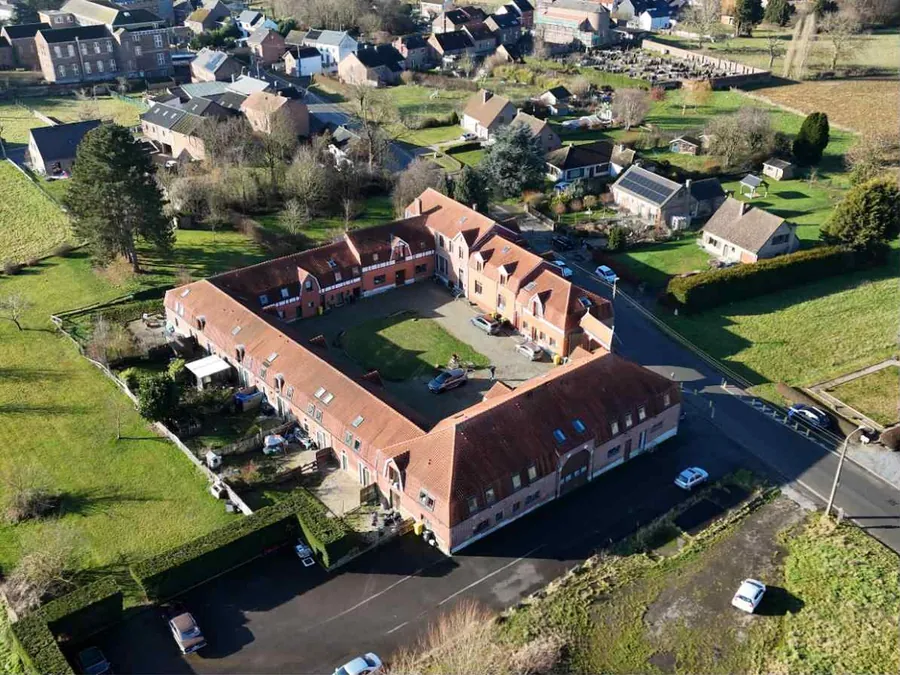 Vue aérienne d'une ancienne ferme en carré à Hannut, transformée en 20 unités