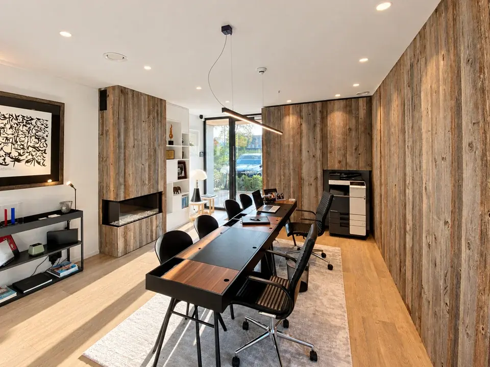 Espace de travail des bureaux Patrimoniale à Waterloo, avec un long bureau en bois et un mur habillé de bois brut
